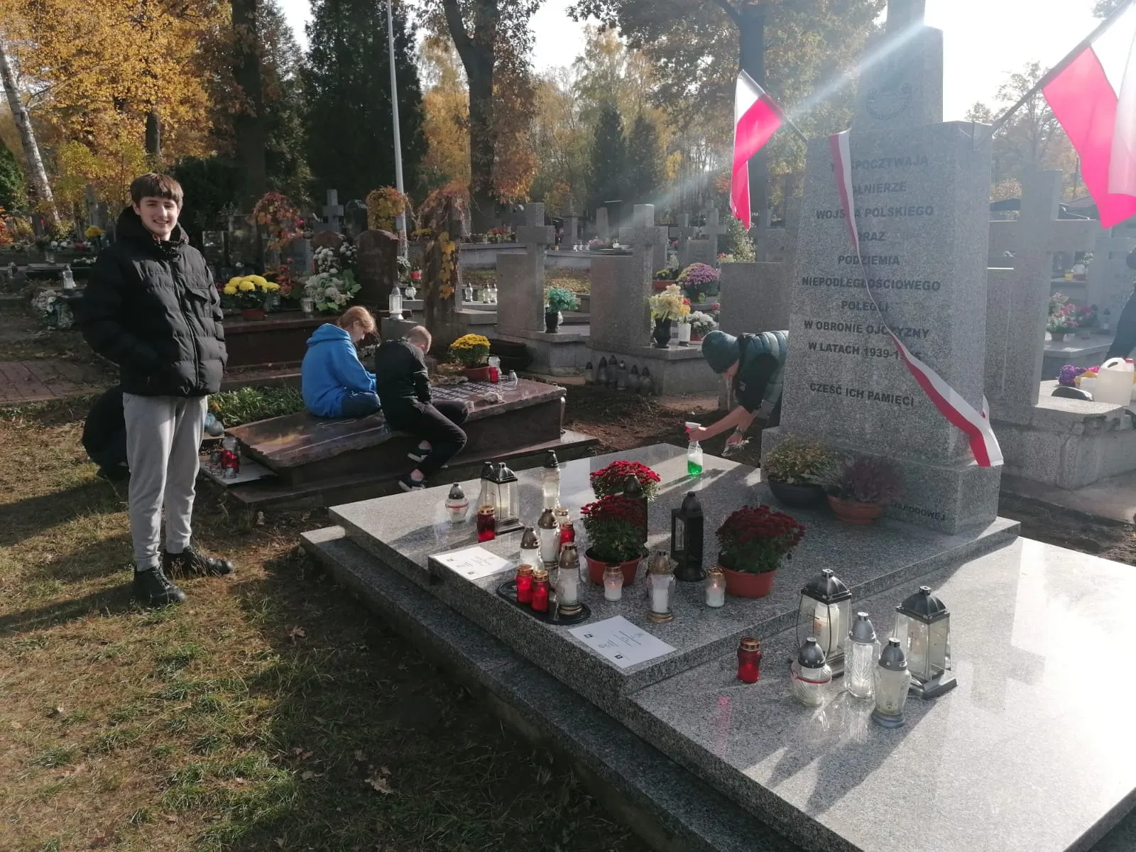 Uczniowie porządkują groby żołnierzy na Cmentarzu w Radości