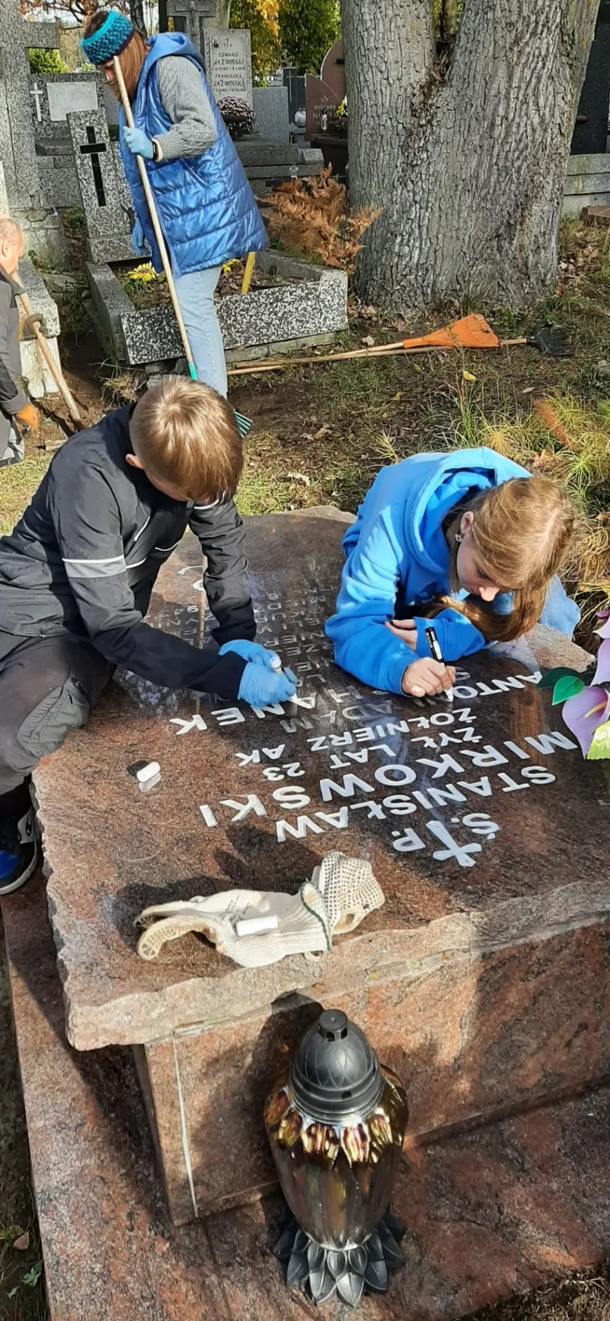 Uczniowie porządkują groby żołnierzy na Cmentarzu w Radości