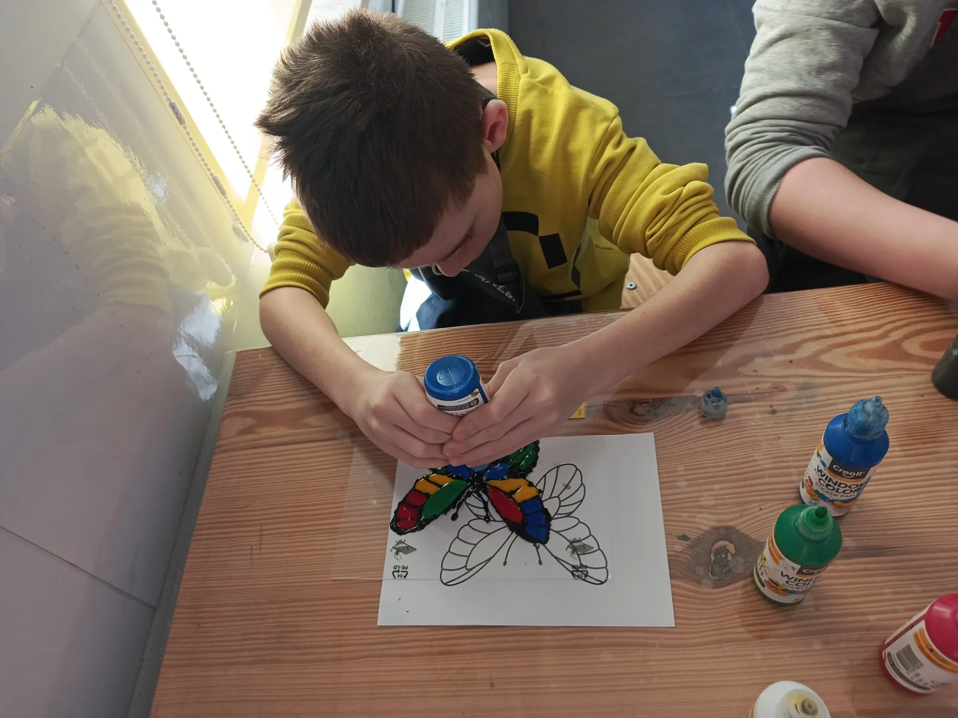 Uczniowie tworzący wiosenne witraże w ArtLab Centrum Wspierania Rodzin