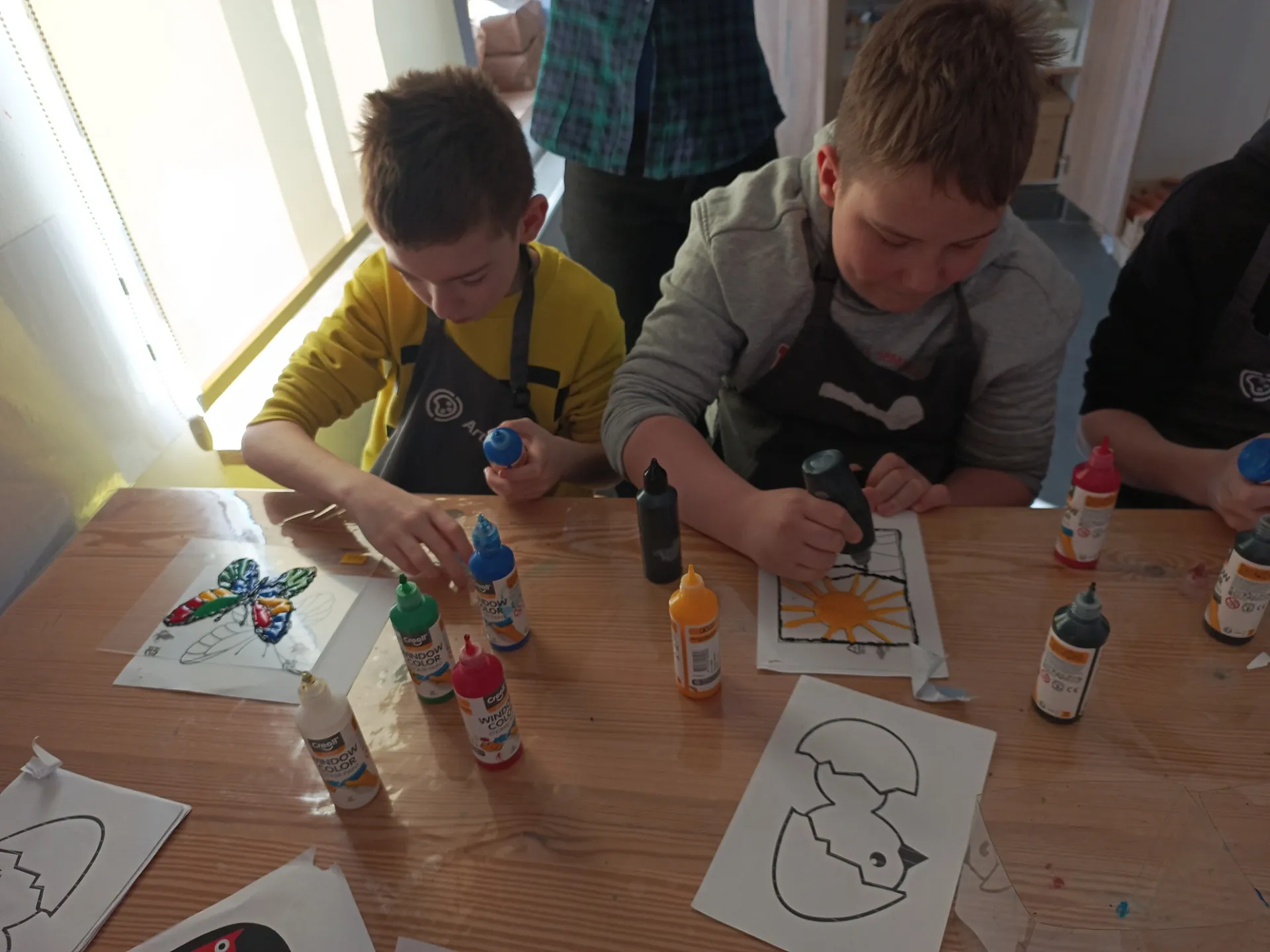 Uczniowie tworzący wiosenne witraże w ArtLab Centrum Wspierania Rodzin